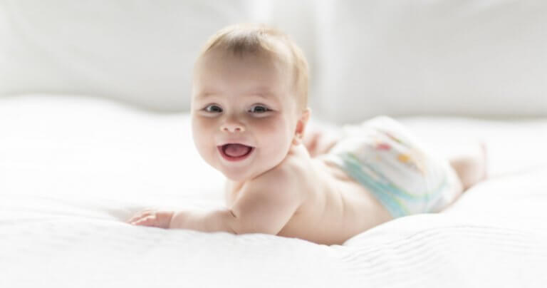 Happy baby on white sheets - Gillespie Approach–Craniosacral Fascial Therapy