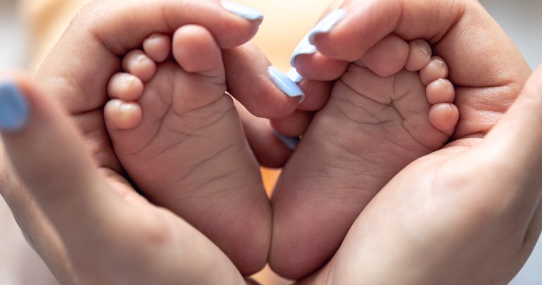 Life-changing - mom holds legs of newborn - Gillespie Approach–Craniosacral Fascial Therapy
