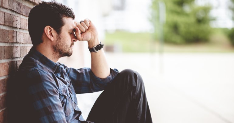 Sacral trauma and depression - man sitting against wall - Gillespie Approach–Craniosacral Fascial Therapy