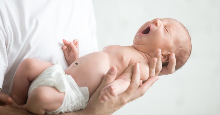 Gillespie Approach at birth - male hands holding baby - Gillespie Approach–Craniosacral Fascial Therapy