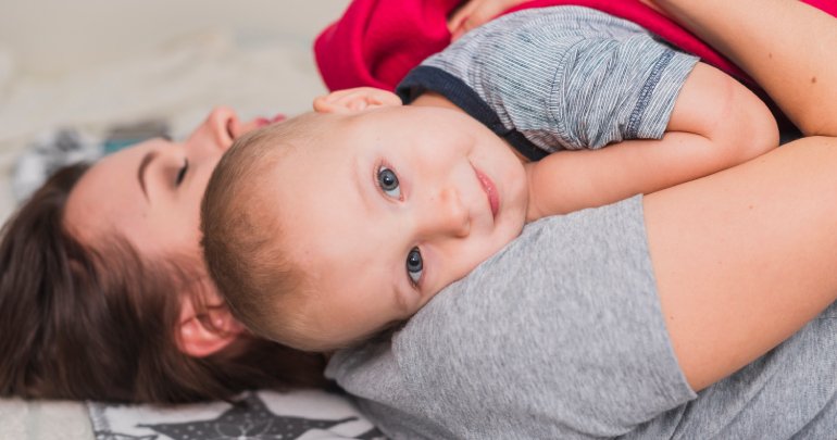 Fussy baby, sucking difficulty, reflux - mother holding baby in bed - Gillespie Approach–Craniosacral Fascial Therapy