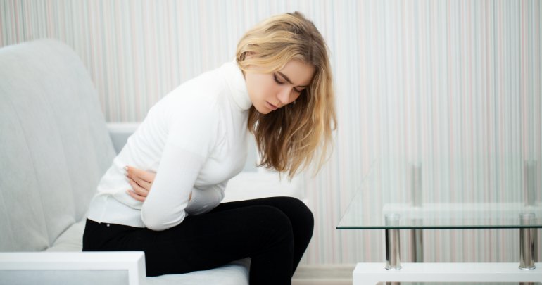 Female pelvic floor - young woman holding stomach and ache - Gillespie Approach–Craniosacral Fascial Therapy