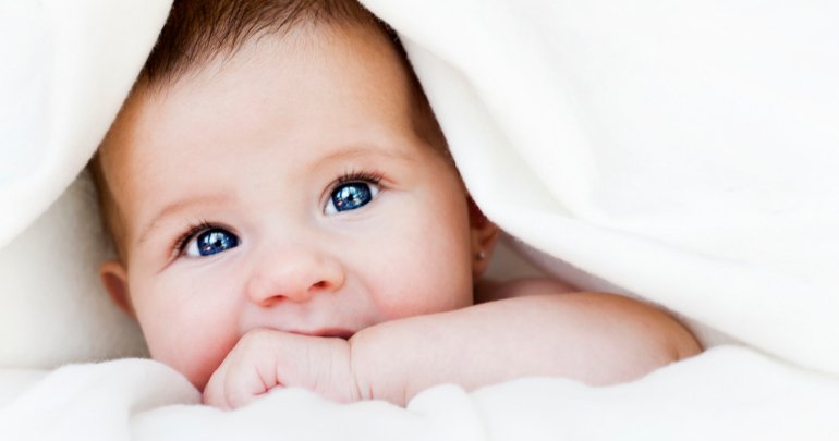 Failure to thrive - baby peeking from under bed sheets - Gillespie Approach–Craniosacral Fascial Therapy