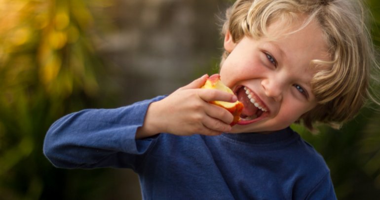Growing out of leads to growing into - child eating apple - Gillespie Approach–Craniosacral Fascial Therapy